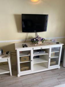 a white entertainment center with a flat screen tv on top at Casa MaGia in Playa de las Americas +13 photos