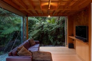 普納凱基的住宿－Punakaiki Forest Retreat，带沙发和平面电视的客厅