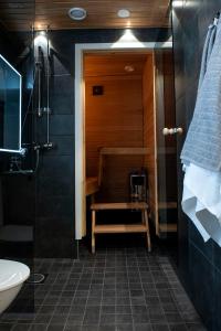 a bathroom with a shower and a bench in it at Otava in Rovaniemi