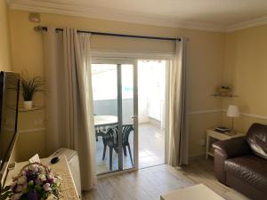 a living room with a sliding door leading to a patio at Casa MaGia in Playa de las Americas