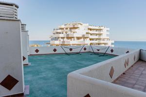 uma varanda com cadeiras e um edifício ao fundo em Benalbeach Penthouse Sea View em Benalmádena