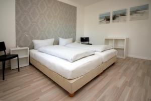 リューネブルクにあるAm Apfelgarten-2 Apartments mit eigenem Parkplatz-Flörekewegのベッドルーム(白いシーツを使用した大型ベッド1台付)