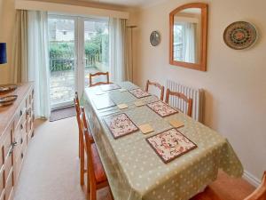 a dining room with a table with chairs and a window at Homewood in Alnwick