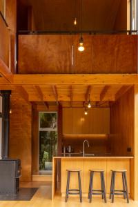 uma cozinha com paredes de madeira e um balcão com bancos em Punakaiki Forest Retreat em Punakaiki