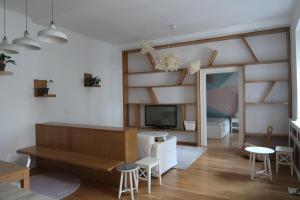 a living room with a couch and a tv and shelves at Home S in Zagreb