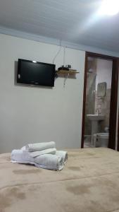 ヴィスコンデ・デ・マウアーにあるPousada Portal do bosqueのベッドルーム1室(ベッド1台、壁掛けテレビ付)