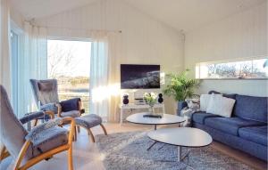 uma sala de estar com um sofá azul e cadeiras em Stunning Home In Borgholm With Wifi em Borgholm