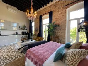 - une chambre avec un lit et un mur en briques dans l'établissement Atelier Art & Suite, à Ayamonte
