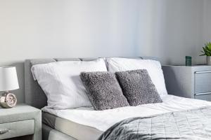 a bed with pillows on it in a bedroom at Villa Garden Żołnierska in Olsztyn