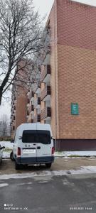 una furgoneta blanca estacionada frente a un edificio de ladrillo en Ferienwohnung Glockenberg, en Altenau