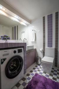 baño con lavadora y alfombra púrpura en Trap's house en Karystos