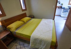 een slaapkamer met een bed met gele en witte lakens bij Recanto dos Ipês 2 in Domingos Martins