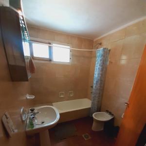 łazienka z umywalką, wanną i toaletą w obiekcie Hermosa casa de campo llena de vida w mieście Bariloche
