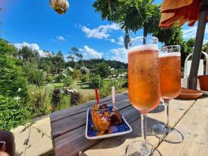 Twee glazen bier en een bord eten op tafel. bij Casa de Coco in Vila Nova de Poiares