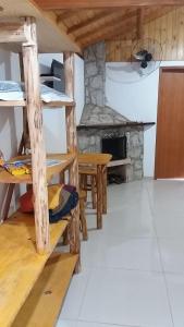 cocina con mesas de madera y chimenea de piedra en Pousada Portal do bosque, en Visconde De Maua