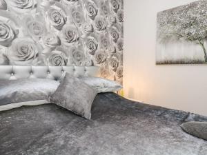 1 dormitorio con 1 cama con una pared cubierta de rosas en The Hideaway en Chacewater