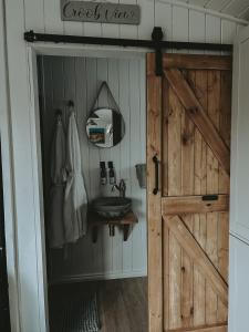 baño con puerta de madera y lavamanos en Slieve Croob Glamping, en Ballyward