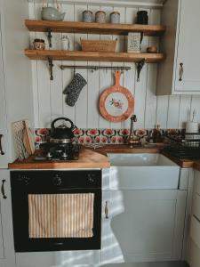 a kitchen with a stove with a tea kettle on it at Slieve Croob Glamping in Ballyward