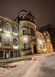 een oud gebouw met een klokkentoren in de sneeuw bij Ferienwohnung Sonneberg in Sonneberg