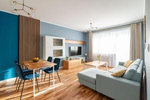 salon z kanapą i stołem w obiekcie Villa Garden Żołnierska w Olsztynie