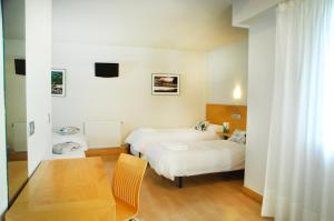 una camera d'albergo con due letti e un tavolo di Hotel Txintxua a Hernani