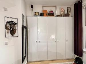 a large white cabinet in a room with a window at Lovely flat near Holland Park in London
