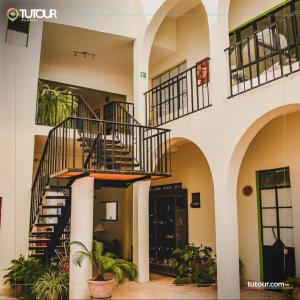 una escalera de caracol en un edificio con plantas en Hotel Doña Chela En Calvillo en Calvillo