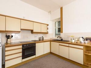 a kitchen with white cabinets and a black oven at Beresford Cottage in North Berwick