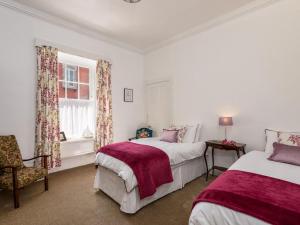 ノース・バーウィックにあるBeresford Cottageのベッドルーム1室(ベッド2台、椅子、窓付)