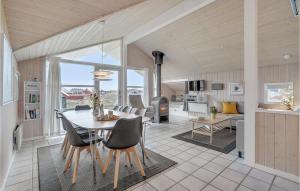 uma sala de jantar e sala de estar com mesa e cadeiras em 3 Bedroom Stunning Home In Hvide Sande em Bjerregård