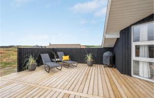a wooden deck with chairs and a table on a house at 3 Bedroom Stunning Home In Hvide Sande in Bjerregård