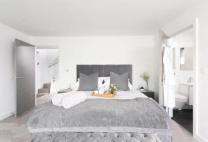 1 dormitorio blanco con 1 cama grande y baño en The Shore, en Mawgan Porth