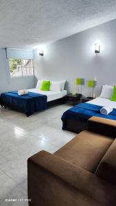 1 dormitorio con 2 camas y sofá en Hotel Loft Dorado Bucaramanga, en Floridablanca