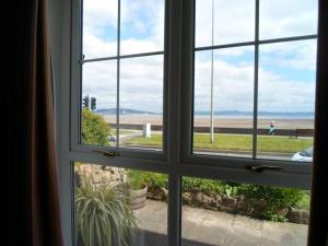 an open window with a view of the beach at Oyster Cottage in The Mumbles