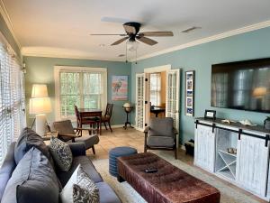 a living room with a couch and a tv at A Wave From It All - 811 Ocean Blvd in Saint Simons