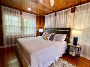 a bedroom with a bed with two lamps and windows at A Wave From It All - 811 Ocean Blvd in Saint Simons +46 photos