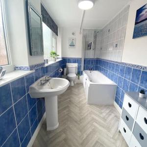 een badkamer met een wastafel, een bad en een toilet bij Scoresby Quarters - Whitby Holiday Home in Whitby