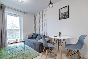 a living room with a couch and a table at Villa Garden Leśna Cisza in Olsztyn