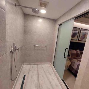 a bathroom with a shower with a glass door at شقة فاخرة تشطيب فندقي حي المهندسين بالقاهرة in Cairo