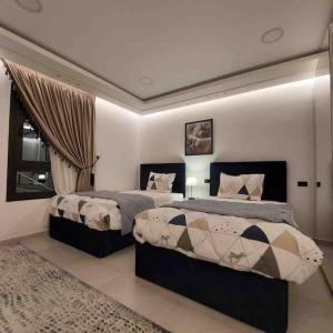 a bedroom with two beds and a window at شقة فاخرة تشطيب فندقي حي المهندسين بالقاهرة in Cairo