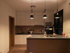 a kitchen with a counter and three pendant lights at Villa Villekulla in Kolašin