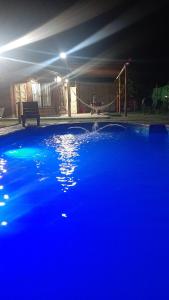 a large blue swimming pool at night with at Cabañas Huazimul in Santa Lucía