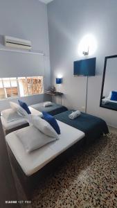 two beds in a bedroom with blue walls at Hotel Loft Dorado in Floridablanca