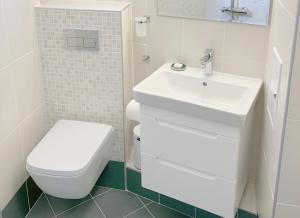 a white bathroom with a toilet and a sink at Orfey Apartment in Sofia