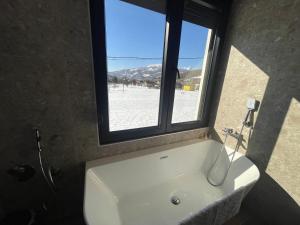 a bathroom with a white tub and a window at Villa Villekulla in Kolašin