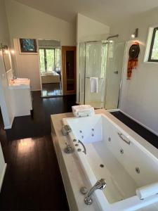 a large bathroom with a large tub and a shower at Blue Cliffs Retreat in Hepburn Springs