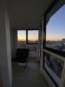 sala de estar con silla y ventana grande en Exotic Pent House with private terrace en Buenos Aires