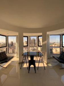 sala de estar con mesa y algunas ventanas en Exotic Pent House with private terrace en Buenos Aires