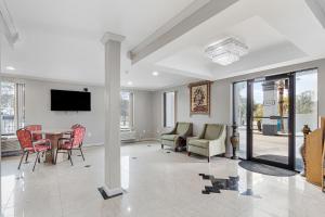 een woonkamer met een tafel en stoelen en een televisie bij Regency Inn Near Boardwalk & Hurlburt Field in Fort Walton Beach