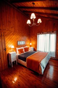 a bedroom with a large bed in a wooden room at Paraiso Patagónico Bungalows and Apart Hotel in El Calafate